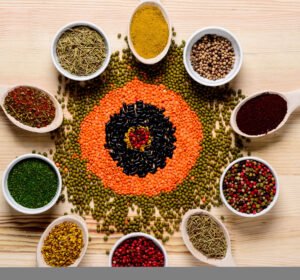 Spices in spoons and on wooden table